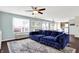 Hardwood floored living room showcasing a blue sectional sofa, stylish rug and views of the kitchen and entry at 3284 Clary Blvd South Dr, Greenwood, IN 46143