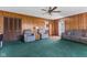 Comfortable living room features wood paneling, ceiling fan, and plush seating with convenient entryways at 3427 Donald Ave, Indianapolis, IN 46224