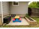 Backyard view of the picnic table beside the house, garden plot and dark storage bin at 3431 W Mooresville Rd, Indianapolis, IN 46221