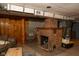 Basement living area showcasing a cozy brick fireplace and rustic wood paneling at 3431 W Mooresville Rd, Indianapolis, IN 46221