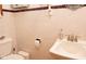 Simple and functional bathroom featuring a toilet, sink, and tiled walls at 3431 W Mooresville Rd, Indianapolis, IN 46221