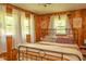 Cozy bedroom with warm wood paneling, a metal frame bed, and lots of natural light at 3431 W Mooresville Rd, Indianapolis, IN 46221