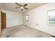 This bedroom has white walls, carpet, a window, and a ceiling fan with a light at 3512 N Wakeland Rd, Paragon, IN 46166