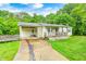 Front exterior view of a one-story home with a covered porch and driveway surrounded by trees at 3512 N Wakeland Rd, Paragon, IN 46166