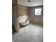 Bathroom featuring marble flooring, vintage-style tub, and window, with unfinished walls at 3526 Evergreen Ave, Indianapolis, IN 46205