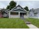 Charming two-story home featuring a covered front porch with brick supports and a well-sized front lawn at 3526 Evergreen Ave, Indianapolis, IN 46205