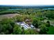 Aerial view of a property featuring greenhouses, a pond, a house and lush greenery at 3533 Alexandria Pike, Anderson, IN 46012