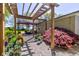 Backyard garden with rows of potted plants and a wooden pergola providing shade on a sunny day at 3533 Alexandria Pike, Anderson, IN 46012