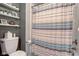 Bathroom featuring shower with decorative curtain, toilet, and decorative storage shelves at 3533 Alexandria Pike, Anderson, IN 46012