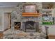 Stone fireplace with wooden mantel and built-in shelving displaying decor and a television at 3533 Alexandria Pike, Anderson, IN 46012