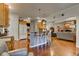 Bright, open kitchen featuring a kitchen island with seating, wood floors, and an adjacent sitting area with a stone fireplace at 3533 Alexandria Pike, Anderson, IN 46012