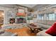 Living room with stone fireplace, wood floors, comfortable seating, and large windows offering natural light at 3533 Alexandria Pike, Anderson, IN 46012