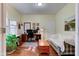 Home office featuring hardwood floors, a desk setup, and a comfortable seating area with natural light at 3533 Alexandria Pike, Anderson, IN 46012