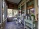 Relaxing sunroom featuring tiled floors, two chairs, and large windows showcasing the outdoor scenery at 3533 Alexandria Pike, Anderson, IN 46012