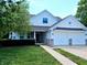 Charming two-story home with a well-manicured lawn, attached two-car garage, and inviting front porch at 3862 Cornwallis Ln, Carmel, IN 46032