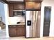 A view of a modern kitchen with stainless steel appliances, granite countertops, dark cabinets and a microwave at 3862 Cornwallis Ln, Carmel, IN 46032