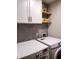 Functional laundry room features modern appliances, stylish backsplash, and convenient storage shelves at 3862 Cornwallis Ln, Carmel, IN 46032