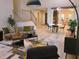An open-concept living room with modern decor, stylish furniture, light hardwood floors and access to the kitchen at 3862 Cornwallis Ln, Carmel, IN 46032