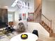 An open-concept living room featuring a fireplace, hardwood floors, and a staircase with wood railing at 3862 Cornwallis Ln, Carmel, IN 46032