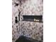 Detailed shower features a leafy accent wall, matte black hardware, and a built-in shelf at 3862 Cornwallis Ln, Carmel, IN 46032