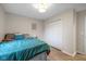 Bright bedroom with hardwood floors, a closet with white doors, and a bed with teal comforter at 3926 Rosefinch Cir, Indianapolis, IN 46228