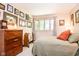 Bedroom with a wooden dresser and neutral-colored walls with framed prints and clock at 3935 Offshore Dr, Columbus, IN 47203