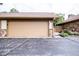 A two-car garage with a stone accent wall and landscaped plants, near the driveway at 3935 Offshore Dr, Columbus, IN 47203