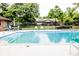 Community pool surrounded by lush greenery and a black fence, with in-pool stairs at 3935 Offshore Dr, Columbus, IN 47203