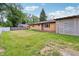 Backyard with a well-maintained lawn, brick house, and wooden fence at 410 E Southport Rd, Indianapolis, IN 46227