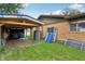 Side yard with covered carport attached to brick house and green lawn at 410 E Southport Rd, Indianapolis, IN 46227