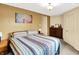 Comfortable bedroom with an earthy palette, a dresser and a patterned bedspread at 4125 S Post Rd, Indianapolis, IN 46239