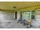 Inviting covered front porch with stone wall, featuring seating area and views of the surrounding landscape at 4125 S Post Rd, Indianapolis, IN 46239