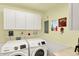 Bright laundry room featuring a modern washer and dryer set and ample cabinet space at 4125 S Post Rd, Indianapolis, IN 46239