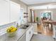 Updated kitchen with granite countertops, white cabinetry, and stainless appliances flows into a dining area at 4345 Guilford Ave, Indianapolis, IN 46205