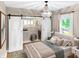 Bright main bedroom with a chandelier, closet with sliding doors, and large window with ample natural light at 4345 Guilford Ave, Indianapolis, IN 46205