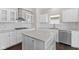 Well-lit kitchen with white cabinets, a center island, stainless steel appliances, and a white subway tile backsplash at 4539 Maldenhair Dr, Indianapolis, IN 46239