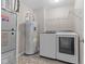 Functional laundry room with modern washer and dryer, water heater, and storage shelves at 4539 Maldenhair Dr, Indianapolis, IN 46239