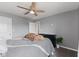 Neutral-toned bedroom features a ceiling fan, grey bedding, and a black dresser beneath a flat-screen television at 4683 W Lawrence Way, New Palestine, IN 46163