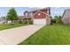 Well-maintained concrete driveway leading to a home with red siding and brick accents at 4683 W Lawrence Way, New Palestine, IN 46163