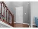 Welcoming foyer with hardwood floors, wooden staircase, and a bright white door at 4683 W Lawrence Way, New Palestine, IN 46163