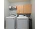 This laundry room features a washer, dryer, cabinet and wire shelving at 4683 W Lawrence Way, New Palestine, IN 46163