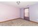 Cozy bedroom features plush gray carpet, and a window with decorative curtain at 4725 W Harrisburg Ct, New Palestine, IN 46163