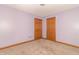 Bedroom featuring neutral carpet flooring, base trim, and two wood paneled doors at 4725 W Harrisburg Ct, New Palestine, IN 46163