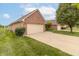 Attached two-car garage showing the long driveway and neatly manicured lawn on a sunny day at 4725 W Harrisburg Ct, New Palestine, IN 46163