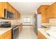 Open kitchen view with wooden cabinets, modern appliances, and seamless transition to the dining area at 4725 W Harrisburg Ct, New Palestine, IN 46163