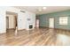 Spacious living room with fireplace, ceiling fan, and wood-look flooring at 4725 W Harrisburg Ct, New Palestine, IN 46163