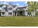 Beautiful white farmhouse with manicured lawn, lush landscaping, and covered porch with black accents at 4808 Lakeview Dr, Greenwood, IN 46143