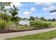 Scenic view of a pond with a fountain, lush landscaping, and a beautiful home in the background at 4808 Lakeview Dr, Greenwood, IN 46143