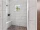 Shower featuring white tile surround, shower seat, and window at 4808 Lakeview Dr, Greenwood, IN 46143