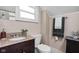 Bathroom with a granite vanity top, white toilet, and decorative accents at 4818 Winthrop Ave, Indianapolis, IN 46205